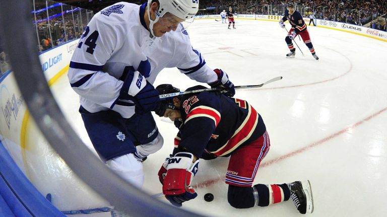 Toronto Maple Leafs center Peter Holland (24) and New York Rangers defenseman Dan Boyle (22) battle for the puck during the second period of a game at Madison Square Garden on Friday, Oct. 30, 2015.