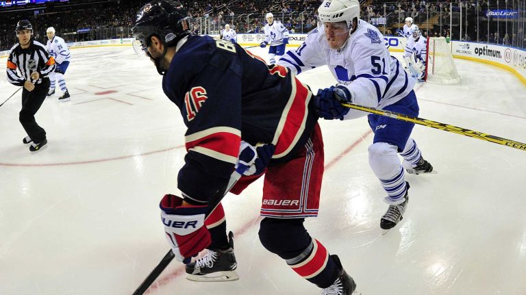 New York Rangers center Derick Brassard (16) is checked into the boards by Toronto Maple Leafs defenseman Jake Gardiner (51) during the first period of a game at Madison Square Garden on Friday, Oct 30, 2015.
