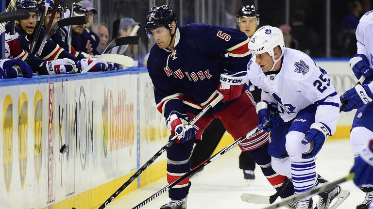 New York Rangers defenseman Dan Girardi (5) battles for the puck with Toronto Maple Leafs forward Rich Clune (25) during the first period of a game at Madison Square Garden on Friday, Oct 30, 2015.