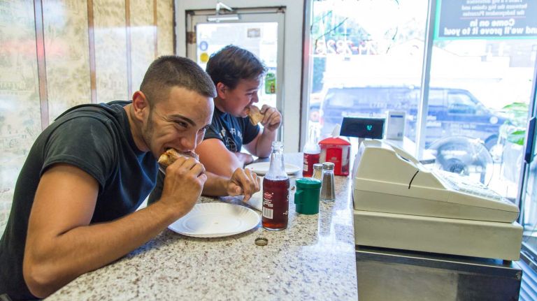 Anthony Montalvo, left, and James O'Connor eat at Tommy's Pizza in Silver Beach.