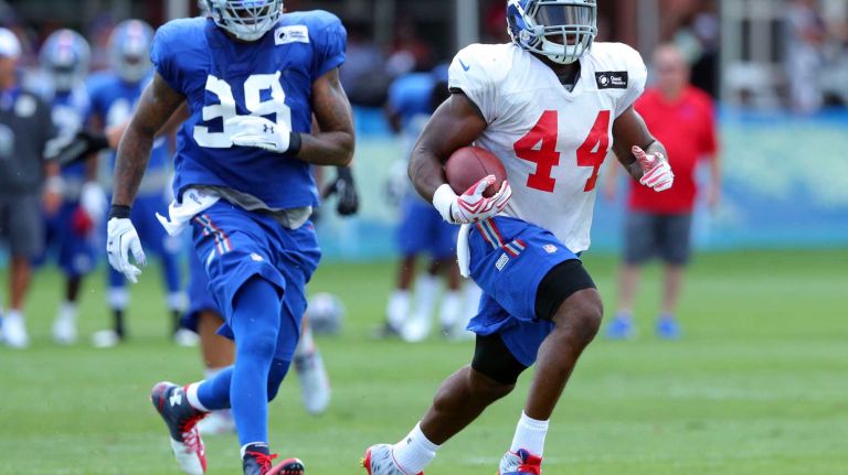 New York Giants running back Andre Williams #44 runs the ball past defensive end Damontre Moore #98 during training camp at the Quest Diagnostics Training Center in East Rutherford, N.J., on Sunday, Aug. 2, 2015.