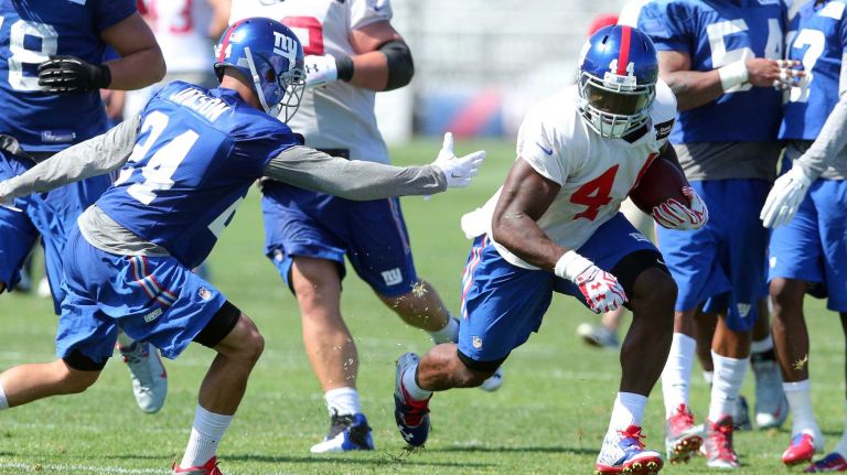Giants running back Andre Williams runs the ball past safety Bennett Jackson during training camp at the Quest Diagnostics Training Center in East Rutherford, New Jersey, on Friday, July 31, 2015.