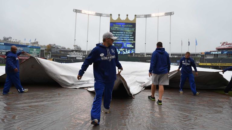 World Series Game 1: Mets vs. Royals 152 Workers at home plate work on the field as it is covered with the rain coming down at Game 1 of the World Series against the Kansas City Royals at Kauffman Stadium on Tuesday, Oct. 27, 2015.