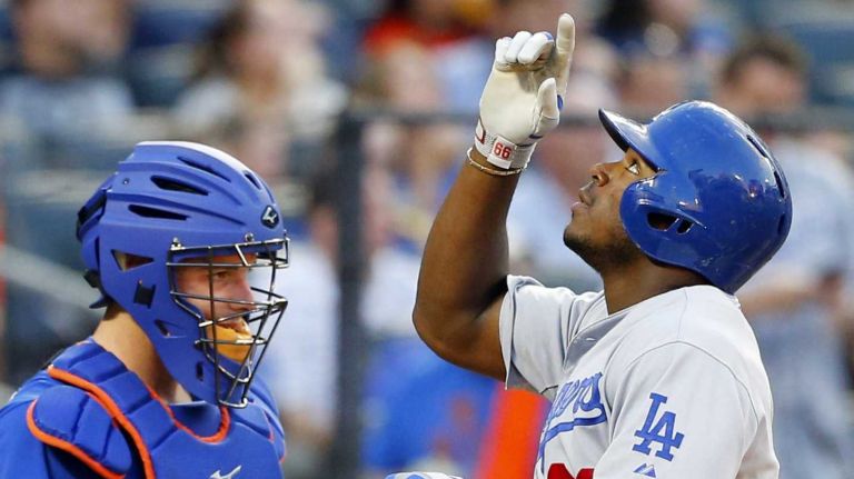 Yasiel Puig of the Los Angeles Dodgers celebrates his third-inning two-run home run as Kevin Plawecki of the Mets looks on at Citi Field on Friday, July 24, 2015.