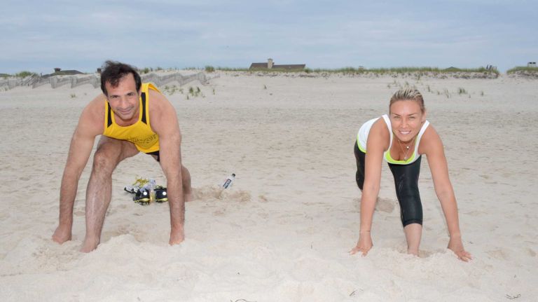 Samer Nsouli and Irina Ovsiannikova stretch before a run at Rogers Beach in Westhampton Beach, Saturday, July 4, 2015.
