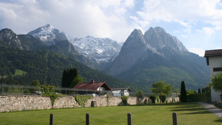 Germany's highest peak, the Zugspitze, is located near Garmisch-Partenkirchen, a German ski resort in southern Bavaria. In the winter, the mountains are perfect for skiing and the lengthy rainy season makes the mountains perfectly green in the spring and summer. Garmisch-Partenkirchen, ritzy resort town at the base of the Alps, made headlines as the site of the G7--and it served as the backdrop of a photo of German Chancellor Angela Merkel and President Obama went viral. The two towns were united in 1935 by Adolf Hitler for the 1936 Winter Olympics, and despite being frequently shortened to 