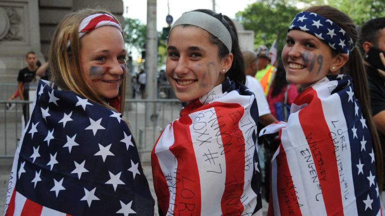 Coleen Dwyer, left, Olivia Seligmann, center, and Sarah Martino, all age 14 and from Huntington, cheer as they wait for the World Cup champion U.S. Women's Soccer Team's ticker-tape parade to start along the Canyon of Heroes in lower Manhattan on Friday, July 10, 2015.