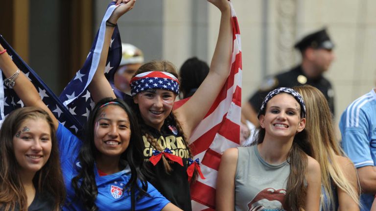 Fans cheer as they wait for the World Cup champion U.S. Women's Soccer Team's ticker-tape parade to start along the Canyon of Heroes in lower Manhattan on Friday, July 10, 2015.