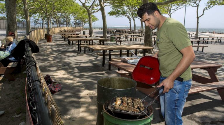 Bakhtiyor, resident at Bay Park, Brooklyn, grills chicken for his family at Manhattan Beach Park on June 8, 2015. ?By Yeong-Ung Yang