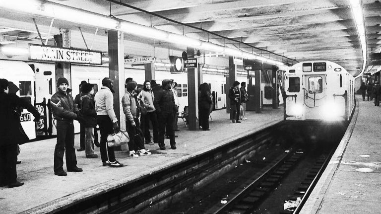 Commuters wait on the platform as a train pulls into the Main Street Flushing subway station. (Jan. 20, 1982)