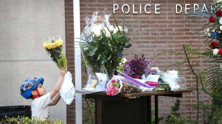 Four-year-old Jimmy Chee, whose family lives near the 105th Precinct in Queens Village, came to the precinct on Monday, May 4, 2015 to leave flowers in honor of NYPD Police Officer Brian Moore, 25, of Massapequa, who passed away from his injuries after being shot on Saturday, May 2.