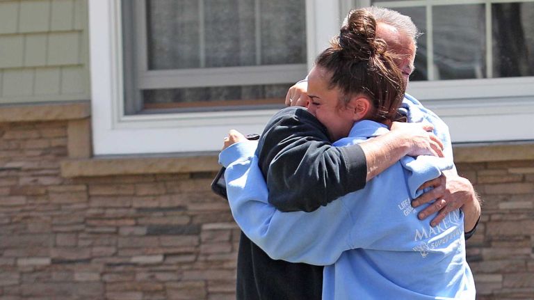 Neighbors and friends in Massapequa react after learning of the death of NYPD Officer Brian Moore on Monday, May 4, 2015.