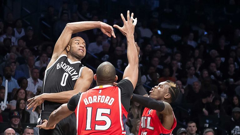 Brooklyn Nets' Jarrett Jack passes the ball out of trouble while getting defensive pressure from the Atlanta Hawks' Al Horford and Dennis Schroder in the fourth quarter during Game 3 of the Eastern Conference quarterfinals at Barclays Center on Saturday, April 25, 2015.