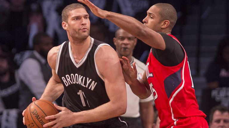 Brooklyn Nets' Brook Lopez looks to pass the ball while getting defensive pressure from Al Horford of the Atlanta Hawks in the first quarter during Game 3 of the Eastern Conference quarterfinals at Barclays Center on Saturday, April 25, 2015.