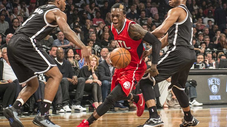 Atlanta Hawks' Dennis Schroder slashes between the defense of the Brooklyn Nets' Joe Johnson and Jarrett Jack in the first quarter during Game 3 of the Eastern Conference quarterfinals at Barclays Center on Saturday, April 25, 2015.