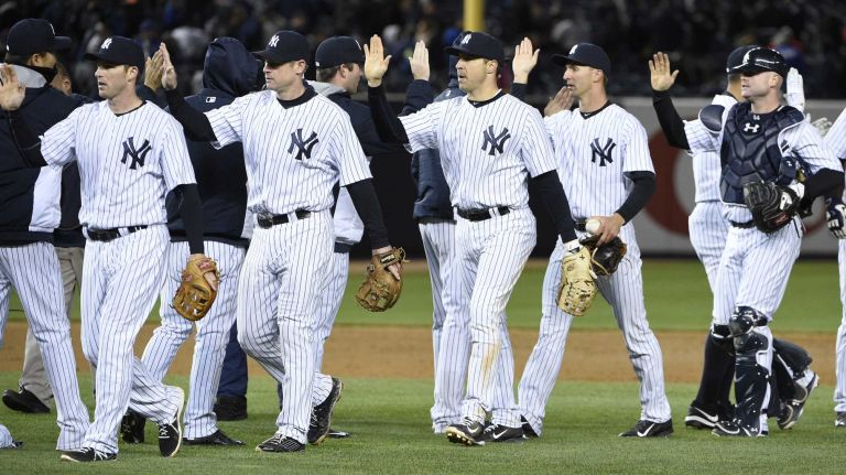 The New York Yankees including New York Yankees first baseman Mark Teixeira, center, celebrate their 6-1 win against the New York Mets in a baseball game at Yankee Stadium on Friday, April 24, 2015.