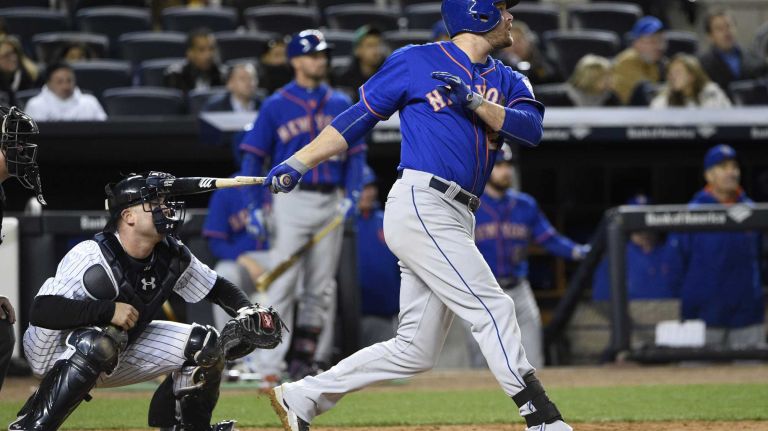 New York Mets first baseman Lucas Duda hits a sacrifice fly against the New York Yankees in a baseball game at Yankee Stadium on Friday, April 24, 2015.
