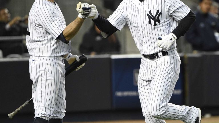 New York Yankees leftfielder Brett Gardner fist bumps New York Yankees center fielder Jacoby Ellsbury after his solo home run in the third inning against the New York Mets in a baseball game at Yankee Stadium on Friday, April 24, 2015.