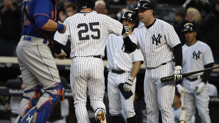 New York Yankees catcher Brian McCann fist bumps New York Yankees first baseman Mark Teixeira after his two-run home run against the New York Mets in a baseball game at Yankee Stadium on Friday, April 24, 2015.