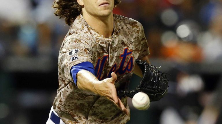 Jacob deGrom #48 of the New York Mets flips the ball to first base for an out in the seventh inning against the Miami Marlins at Citi Field on Monday, Sept. 15, 2014 in the Queens Borough of New York City.