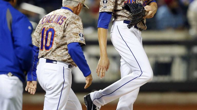Mnager Terry Collins #10 of the New York Mets checks on Jacob deGrom #48 after he was hit with a batted ball in the seventh inning against the Miami Marlins at Citi Field on Monday, Sept. 15, 2014 in the Queens Borough of New York City.
