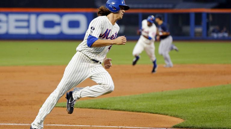 Jacob deGrom #48 and Curtis Granderson #3 of the Mets run the bases to score on a second inning double against the Atlanta Braves from teammate Daniel Murphy at Citi Field on Tuesday, July 8, 2014 in the Queens Borough.