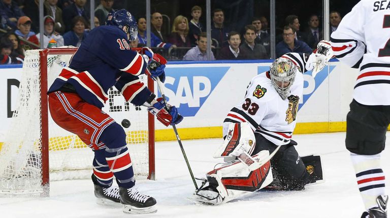 Scott Darling of the Chicago Blackhawks makes a save in the third period as J.T. Miller of the New York Rangers looks for a rebound at Madison Square Garden on Wednesday, March 18, 2015.