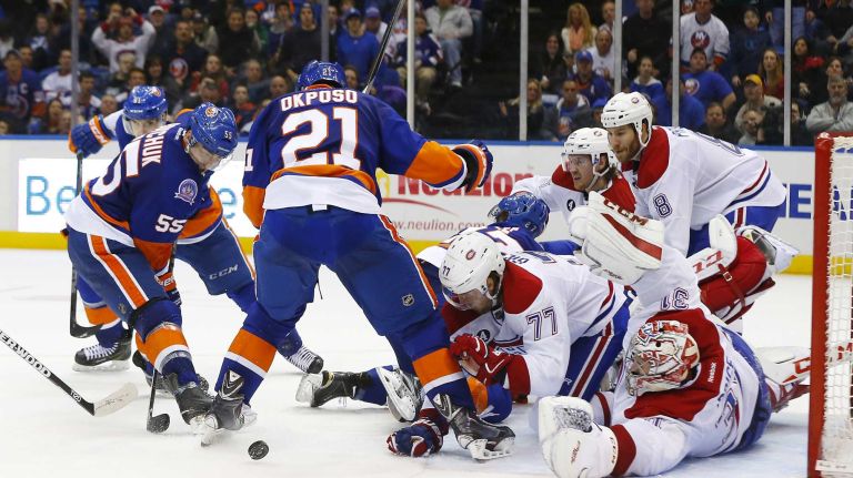 Carey Price and Tom Gilbert of the Montreal Canadiens defend a third period scoring chance against Johnny Boychuk and Kyle Okposo of the New York Islanders at Nassau Coliseum on Saturday, March 14, 2015 in Uniondale.