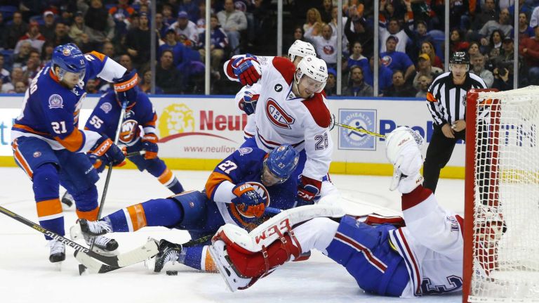 Jeff Petry and Carey Price of the Montreal Canadiens defend a third period scoring chance against Anders Lee of the New York Islanders at Nassau Coliseum on Saturday, March 14, 2015 in Uniondale.