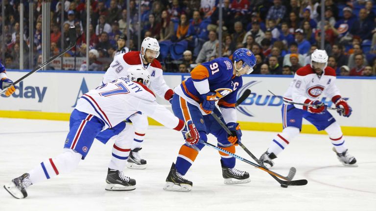 John Tavares of the New York Islanders tries to skate with the puck against Max Pacioretty of the Montreal Canadiens during the first period at Nassau Coliseum on Saturday, March 14, 2015.
