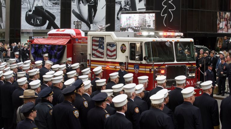 The casket carrying the body of FDNY firefighter Michael Davidson arrives at St. Patrick's Cathedral atop his company's fire engine for his funeral mass on Tuesday.