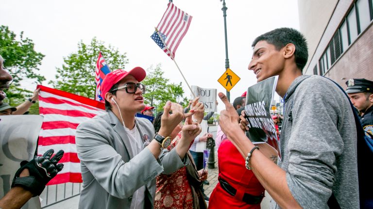Pro-Trump demonstrator Jovi Val, 26, of Queens, left, and an anti-Trump protester along the West Side Highway in Manhattan before the president's visit to the Intrepid Air and Space Museum, on May 4, 2017.