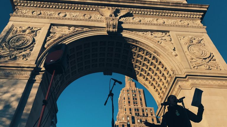 A woman speaks onstage under the arch at Washington Square Park in Manhattan during the International Women's Strike rally on Wednesday, March 8, 2017.