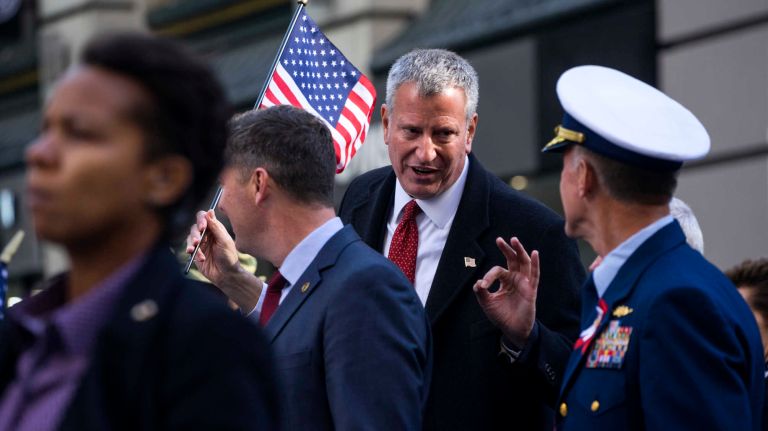 New York Mayor Bill de Blasio speaks with a service member as they march up Fifth Avenue during the Veterans Day Parade on Friday, Nov. 11, 2016.