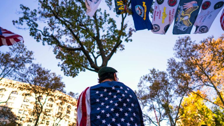 An American Flag is worn by a participant in Madison Square Park for a service during the Veterans Day Parade in New York Friday, Nov 11, 2016.