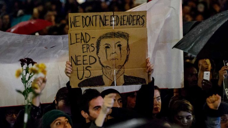 An anti-Trump protester holds up a sign in Union Square before marching uptown to Trump Tower on Wednesday, Nov. 9, 2016.
