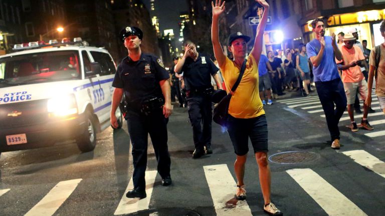 A demonstrator raises her arms during a march through Manhattan on July 7, 2016, to protest the deaths of two black men at the hands of police in Louisiana and Minnesota. 