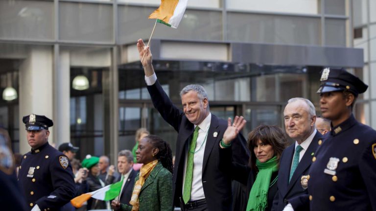 Mayor Bill de Blasio, with his wife Chirlane McCray to his left, and Police Commissioner William Bratton, with his wife Rikki Klieman, march up Fifth Avenue during the St. Patrick's Day Parade in Manhattan on March 17, 2016.