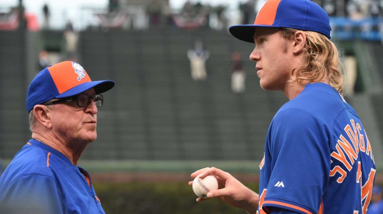 New York Mets pitching coach Dan Warthen (59) talks with New York Mets starting pitcher Noah Syndergaard (34) during batting practice before Game 4 of the NLCS against the Chicago Cubs at Wrigley Field on Wednesday, Oct. 21, 2015.