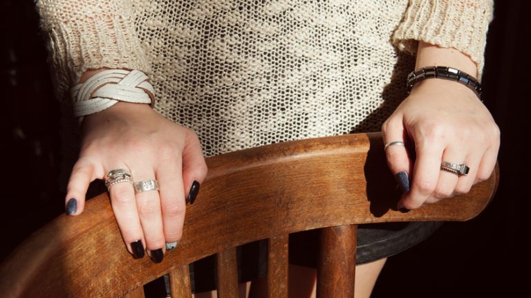 Undocumented and in high school 1 Two hands of young woman on chair.