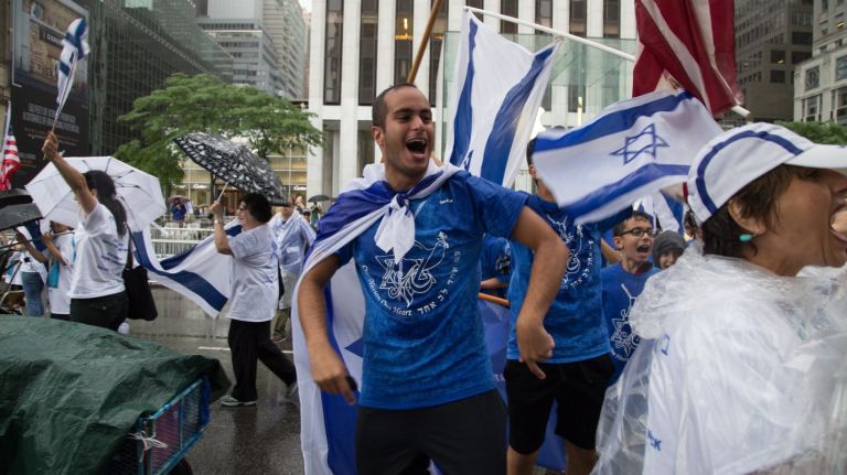 Festive marchers in the Celebrate Israel Parade walk along Fifth  Avenue in Manhattan Sunday.