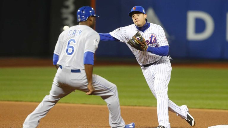 New York Mets shortstop Wilmer Flores gets Kansas City Royals centerfielder Lorenzo Cain as he tries to get Kansas City Royals first baseman Eric Hosmer (35) in first inning during Game 3 of the World Series against the Kansas City Royals at Citi Field on Friday, Oct. 30, 2015.