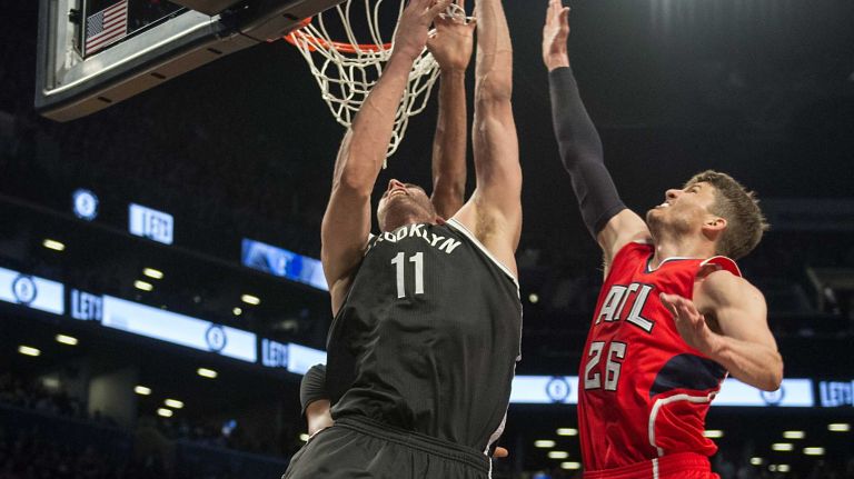 Brooklyn Nets' Brook Lopez scores on a reverse layup over Al Horford and Kyle Korver of the Atlanta Hawks in the fourth quarter during Game 3 of the Eastern Conference quarterfinals at Barclays Center on Saturday, April 25, 2015.