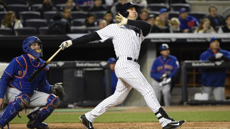 New York Mets catcher Kevin Plawecki and New York Yankees first baseman Mark Teixeira watch the flight of Teixeira's two-run home run in the third inning of a baseball game at Yankee Stadium on Friday, April 24, 2015.
