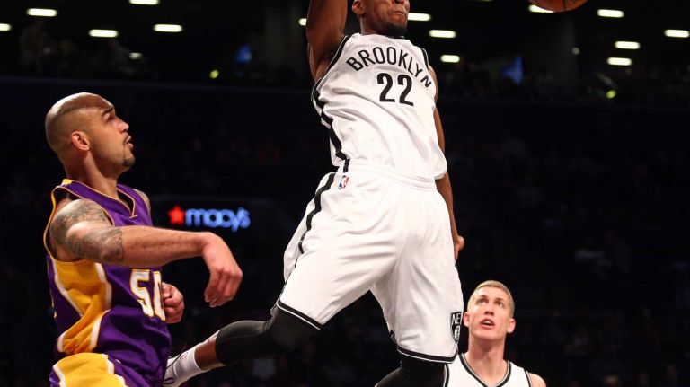 Brooklyn Nets shooting guard Markel Brown #22 dunks over Los Angeles Lakers center Robert Sacre #50 during the first quarter of a game at Barclays Center on Sunday, March 29, 2015.