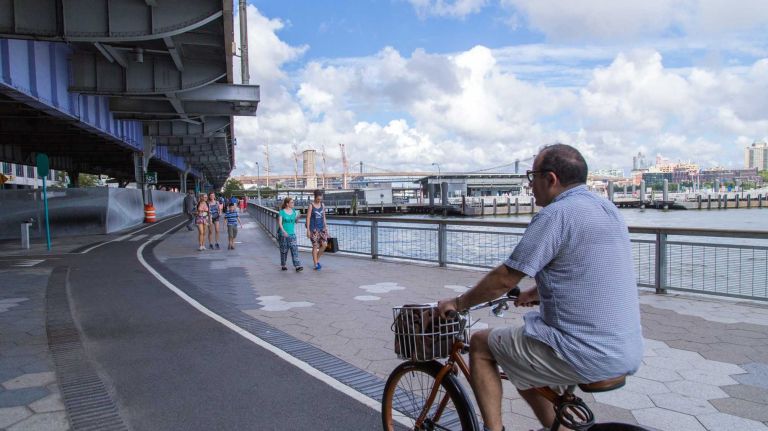 People ride bikes and walk along the East River bikeway in Manhattan's Financial District on Aug. 20, 2015.