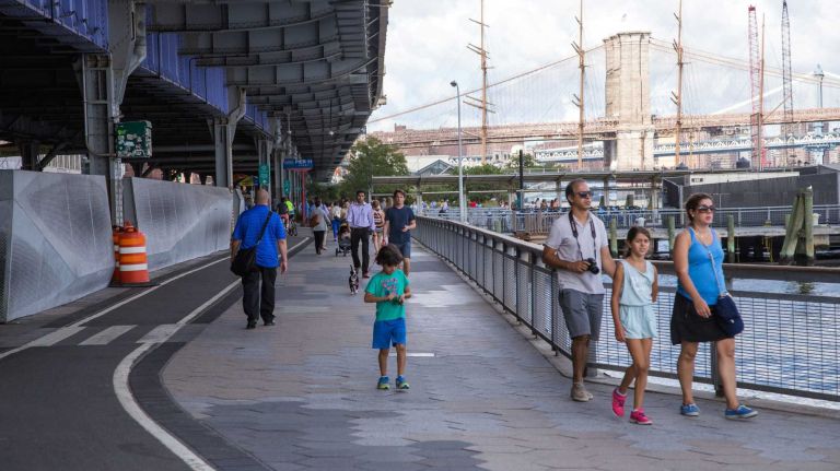 People ride bikes and walk along the East River bikeway in Manhattan's Financial District on Aug. 20, 2015.