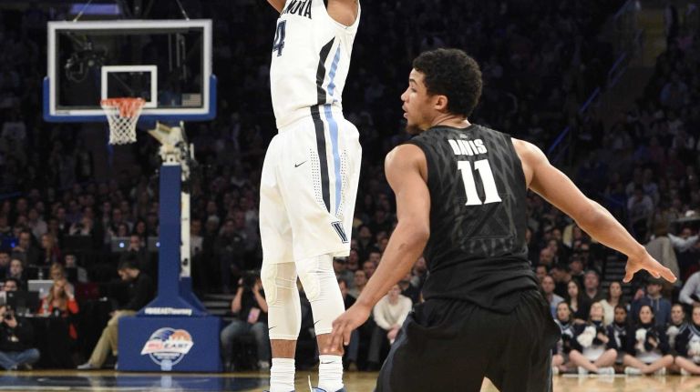 Villanova Wildcats guard Darrun Hilliard II sinks a three-point jump shot as Xavier Musketeers guard Dee Davis looks on during the final game of the Big East basketball tournament at Madison Square Garden on Saturday, March 14, 2015.