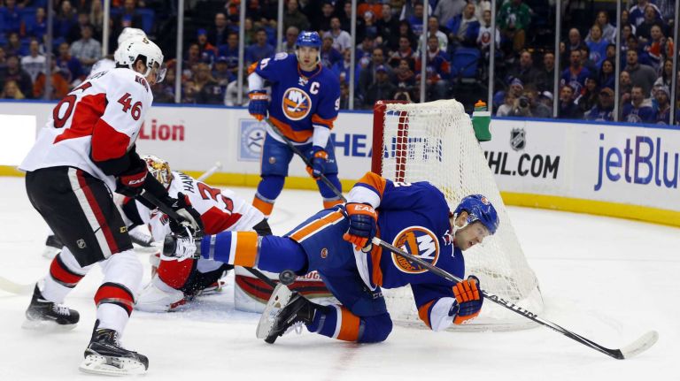 Josh Bailey of the New York Islanders is knocked down near the net in the first period by Patrick Wiercioch of the Ottawa Senators at Nassau Coliseum on Friday, March 13, 2015.