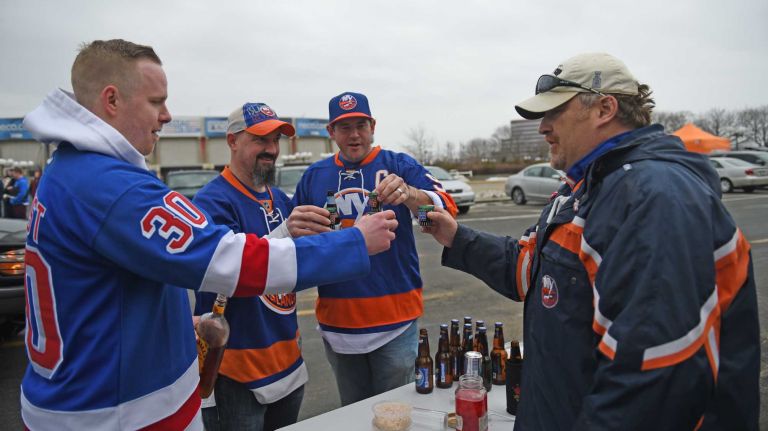 Fans at Islanders vs. Rangers 41 James McCaffrey of Port Washington, James Fenwick and Rich Finley of Kamloops, Canada, and Alex Klein of Roslyn toast in the parking lot of Nassau Coliseum before the last Islanders-Rangers regular-season game at the Coliseum on March 10, 2015.